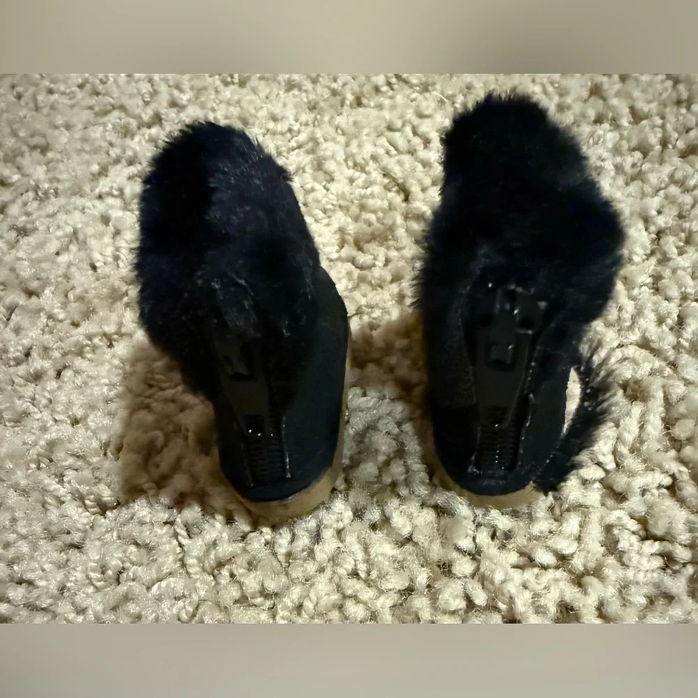 Labubu accessories: black shearling boot with zipper, and black glasses